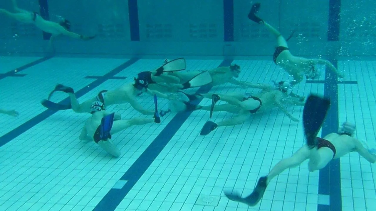 Underwater hockey match in play on the pool floor